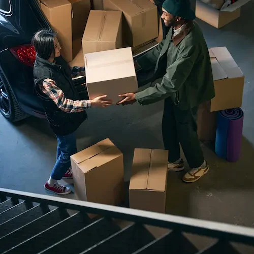 teen-and-adult-moving-boxes-into-car-trunk-2026-09-23-21-53-04-utc